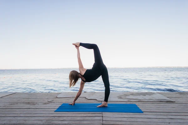 Image of a pretty woman doing yoga at the lake — Stock Photo, Image