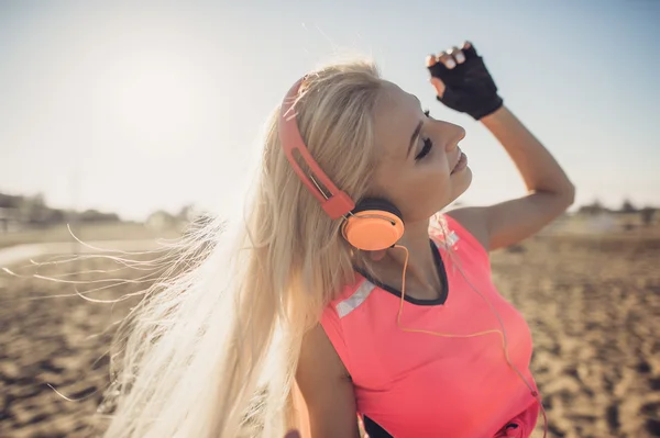 Success fitness woman concept with sports armband and earphones. Enjoying life and music