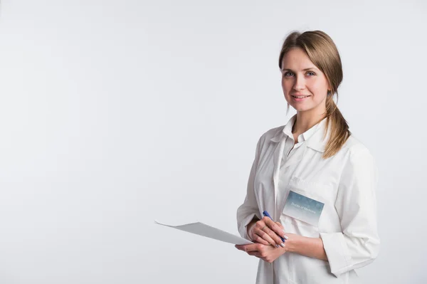 Bella infermiera sorridente e prendere appunti su uno sfondo bianco isolato — Foto Stock