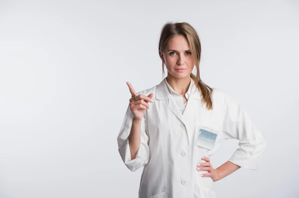 Enfermera doctora joven presentando y mostrando espacio de copia para producto o texto. Caucásico profesional médico femenino aislado sobre fondo blanco . —  Fotos de Stock