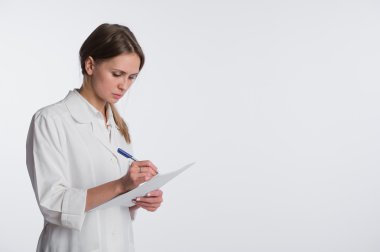Beautiful nurse smiling and taking notes on a white isolated background clipart