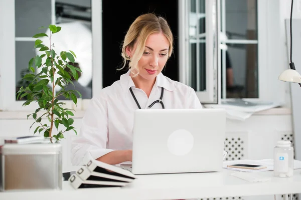 Portret van Happy jonge vrouwelijke arts werken op Computer op haar kantoor — Stockfoto