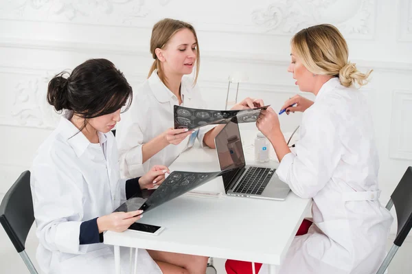 Grupo de médicos que se reúnen en una oficina del hospital examinando rayos X — Foto de Stock