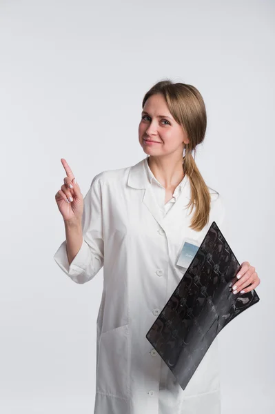 Doctor sosteniendo una radiografía y apuntando a espacio de copia en blanco, fondo blanco — Foto de Stock