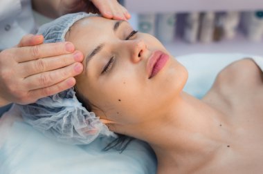 Güzel ve genç birbayan rahatlatıcı yüz masaj güzellik Spa ile