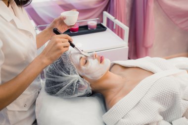 Spa salonda yüz kozmetik prosedür sırasında genç kadın portresi