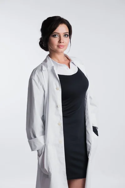 彼女の首輪を持って、白い背景に、立っている女性医師 — ストック写真