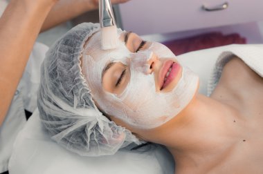 genç kadın maskesi uygulayarak spa prosedürler