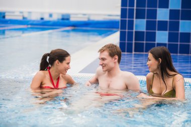 Neşeli arkadaşları yüzme havuzunda rahatlatıcı