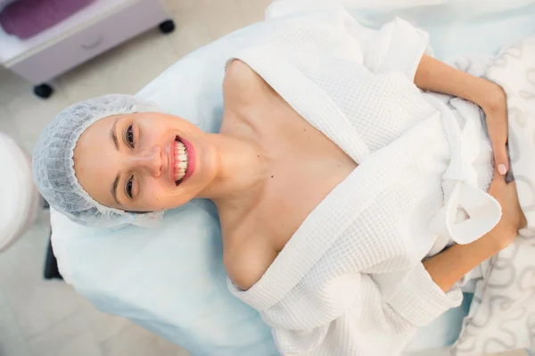 Mooie geduldige vrouw glimlach liggend op bed in operatie kamer ziekenhuis — Stockfoto