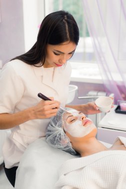 Spa yordamı yüzünde sahip genç güzel kadın