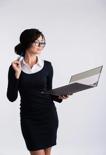 Joven mujer caucásica con vestido azul oscuro, camisa blanca, sosteniendo una carpeta de carpeta de carpeta de anillo y pluma. Aislado sobre fondo claro . —  Fotos de Stock