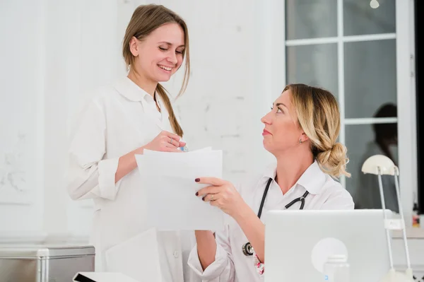 Médico y enfermera mirando los documentos en el consultorio médico — Foto de Stock