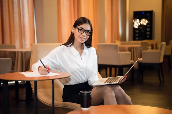 El retrato de la mujer de negocios con el portátil escribe en el documento en la cafetería — Foto de Stock