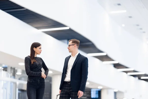 Zakenmensen in formele kleding lopen met wieltassen op luchthaventerminal — Stockfoto