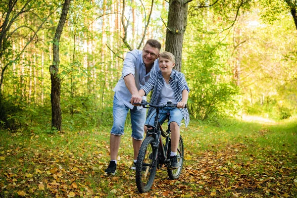 Père enseigne à son fils à faire du vélo à la campagne — Photo