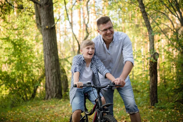 Père enseigne à son fils à faire du vélo à la campagne — Photo