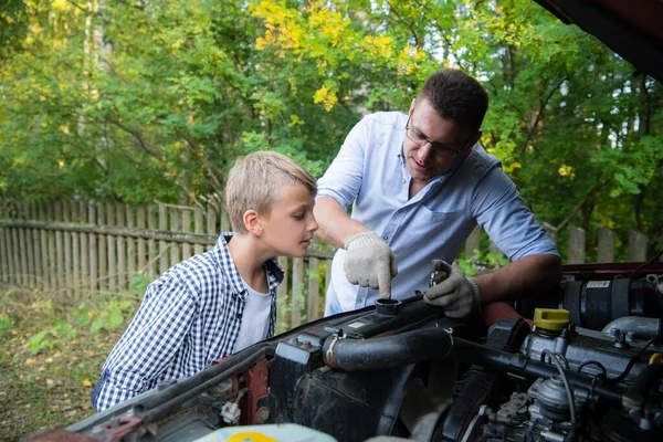 父は息子に車の修理方法を教えて — ストック写真