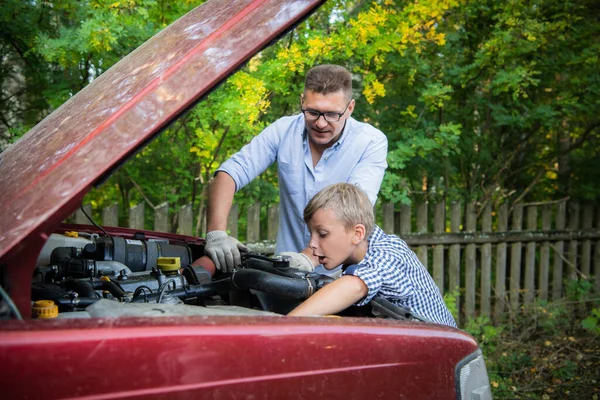 El padre y el hijo revisando el motor del coche. — Foto de Stock