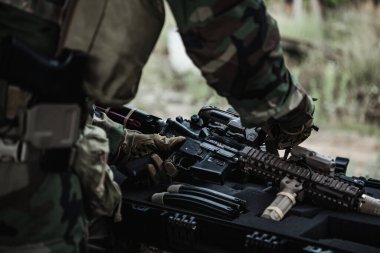 Silahlı bir asker, yıkılmış şehirde bir saldırı tüfeğini indiriyor. Askeri ve kurtarma operasyonu konsepti.