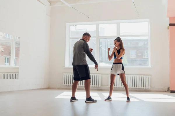 Nella sala da boxe, un allenatore esperto insegna a una ragazza la posizione corretta. — Foto Stock