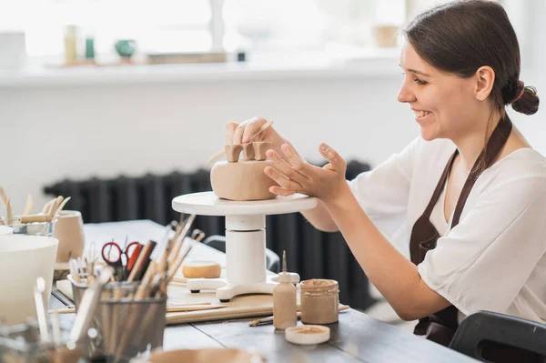 Detailní záběr ženského hrnčíře držet hůl a dělat ozdoby na hliněné nádobí. Clay Master vstřikování jílu produkt. Koncept keramického umění a hobby. — Stock fotografie