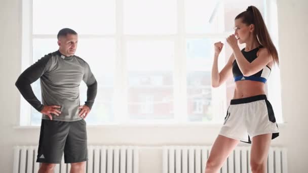 Kobieta trenuje boks z osobistym trenerem. Instruktor uczy bokserki walki razem. — Wideo stockowe