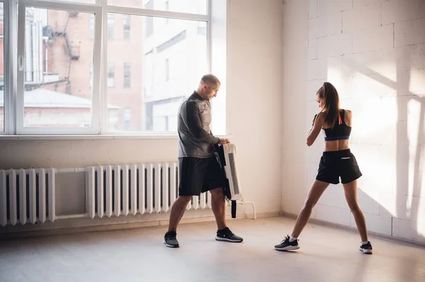 Tréninkový souboj mužských a ženských kickboxerů. Cvičení kopání a údery do boxerské tlapy. Práce ve dvojicích — Stock fotografie