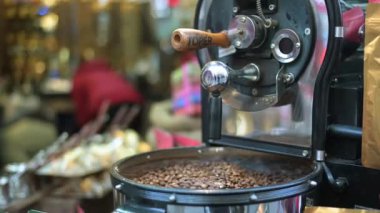 Sokak kahvecisindeki kahve kızartma makinesi. Tankın içine kahve çekirdeği koyan tanınmayan bir satıcı..