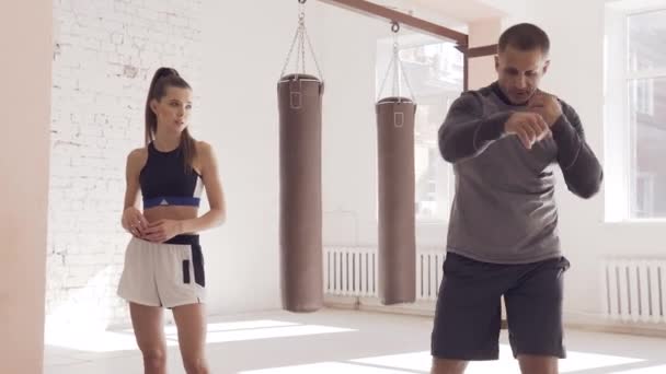 Egy fiatal, vonzó boksz edző felkészít egy csinos lányt a versenyre. — Stock videók