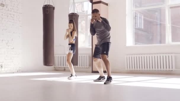 Il primo allenamento di una combattente alle prime armi nel kickboxing, l'allenatore mostra i colpi — Video Stock