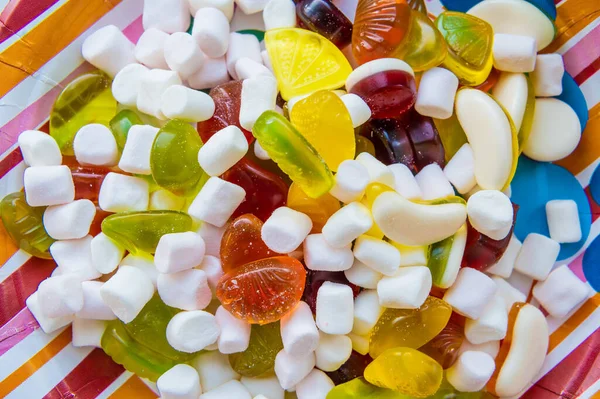 Vegyes mályvacukor cukorka cukorral, banán zselé cukorka, háttér édességekkel, mályvacukor figura, zselés gyűrűk — Stock Fotó