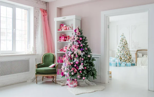 Belle camere decorate holdiay con alberi di Natale, scaffale e rosa regali blu su di esso, interno casa sedia verde — Foto Stock