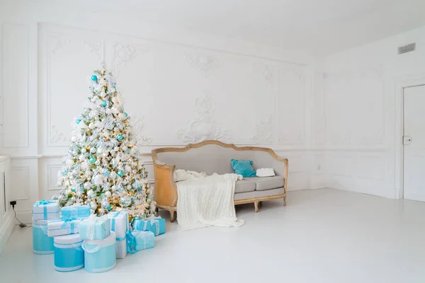 Zarif bir koltuğu olan şık bir Noel iç mimarisi. Huzur evi. Oturma odasındaki ağacın altında hediyeler sunar. — Stok fotoğraf