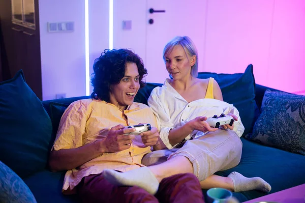 Foto de pareja joven jugando videojuegos en casa por la noche — Foto de Stock