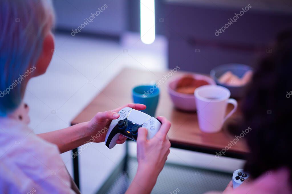 Moscow - November 28 2020: Woman holding new Dualsense controller joystick of Sony PlayStation 5 gaming console at home. Playing games with her boyfriend