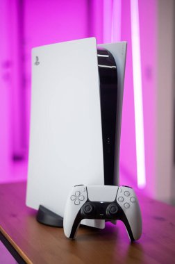 Yeni Sony oyun konsolu PlayStation 5 ve pembe neon ışıklı çift duyu kumandası. Moskova - 28 Kasım 2020.
