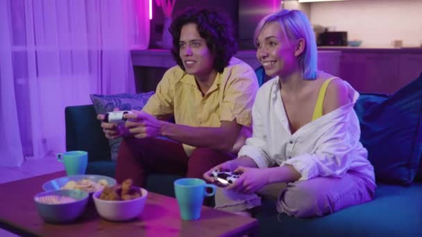 Happy boyfriend and girlfriend playing video games and holding