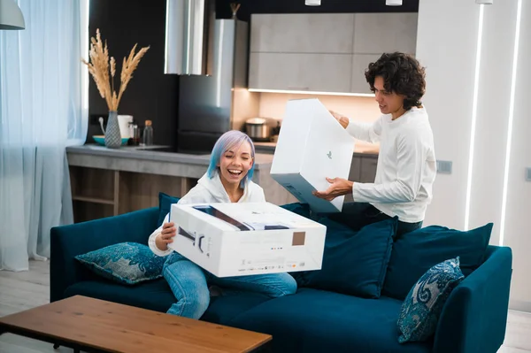 Happy young couple unpacking brand new gaming console Sony Playstation 5 at home. Moscow - November 28 2020. — Stock Photo, Image