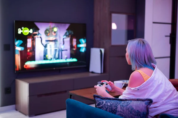 Chica adolescente con colorido pelo azul y rosa mantenga joystick y jugar videojuegos en casa por la noche. — Foto de Stock