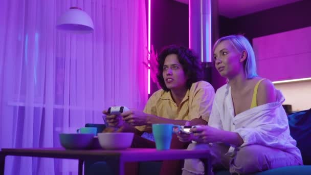 Junge fröhliche kaukasische Eheleute spielen zu Hause Videospiele gegeneinander und genießen die Freizeit — Stockvideo