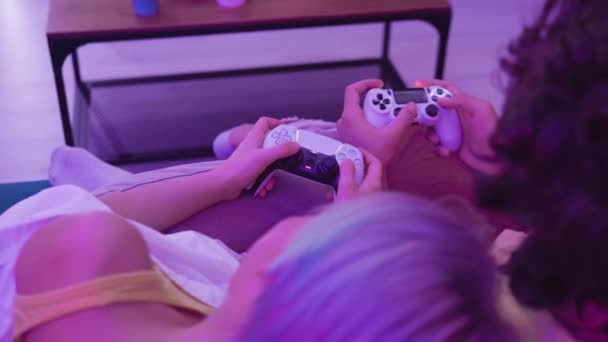 Couple à la maison jouant PlayStation 5 avec différentes générations de joysticks de console : PS5 DualSense contrôleur et PS4 DualShock manette de jeu dans les mains des joueurs. Moscou - 28 novembre 2020. — Video