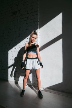 Mükemmel vücut ve karın kasları olan genç bir bayan sporcu sabahın erken saatlerinde antrenmana hazırlanıyor.