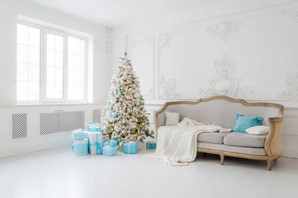 Elegante interior de Navidad con un elegante sofá. Hogar confortable. Regalos debajo del árbol en la sala de estar —  Fotos de Stock