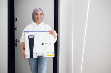 Mutlu, heyecanlı kadın yeni Sony PlayStation 5 oyun konsoluyla sevgilisine sürpriz yapmak için eve geliyor. Noel için almıştı. Moskova - 28 Kasım 2020