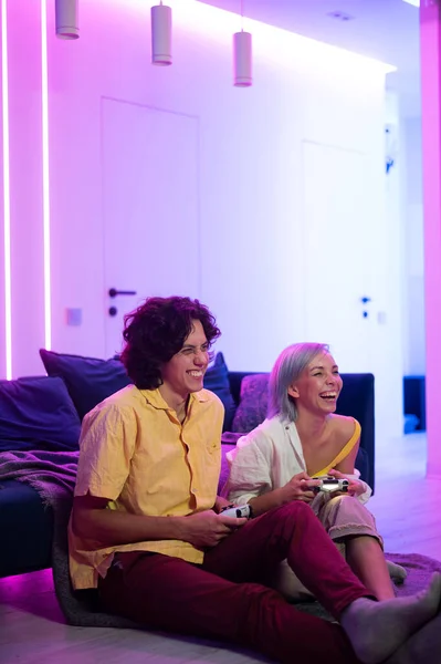 La meilleure équipe qui soit. Beaux amants à une date à l'intérieur, ils jouent à des jeux vidéo. Leur équipe a gagné, ils donnent cinq à célébrer. — Photo