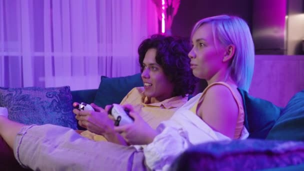 Unga par, kvinna och man inne i rummet lämnat titta på en tv-skärm spela tv-spel hemma. — Stockvideo
