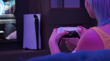PlayStation 5, evdeki televizyon ekranının yanında. Kadın elleri kameranın önünde joystick 'i tutuyor. Moskova - 28 Kasım 2020.