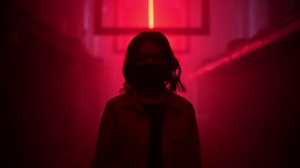 Egy maszkos nő áll egy sötét alagútban, piros lámpákkal. Exit és pandémiás depresszió koncepció. Koronavírus okozta depresszió, karantén, COVID 19. Emberi egészség. — Stock videók