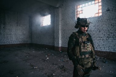 Dışarıda yağmur yağarken askeri bir operasyondan dinlenen düşünceli bir asker..